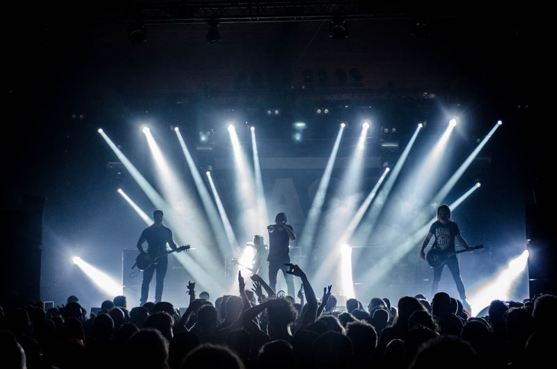 A rock band performing live on stage in front of a crowd