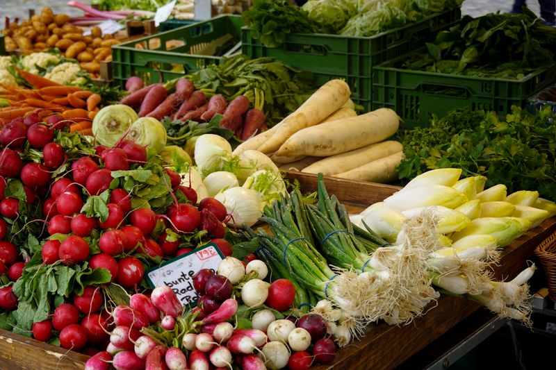 A farmers market stall piled with fresh, colorful vegetables