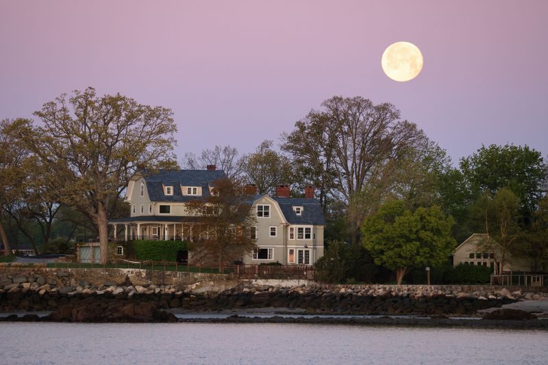 A big house under a full moon at dusk